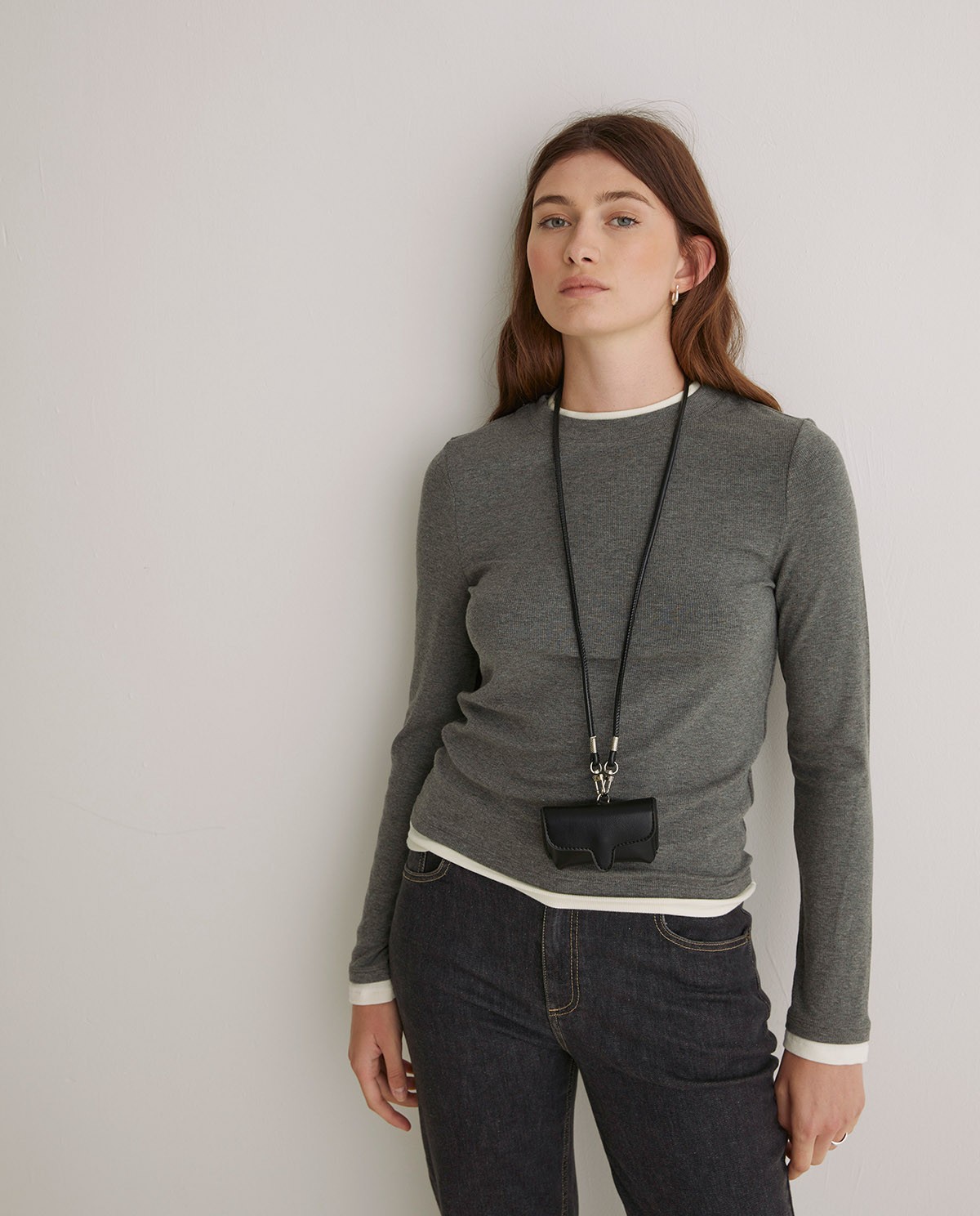 Black rigid mini wallet by Yerse with snap-button closure and removable neck strap 1