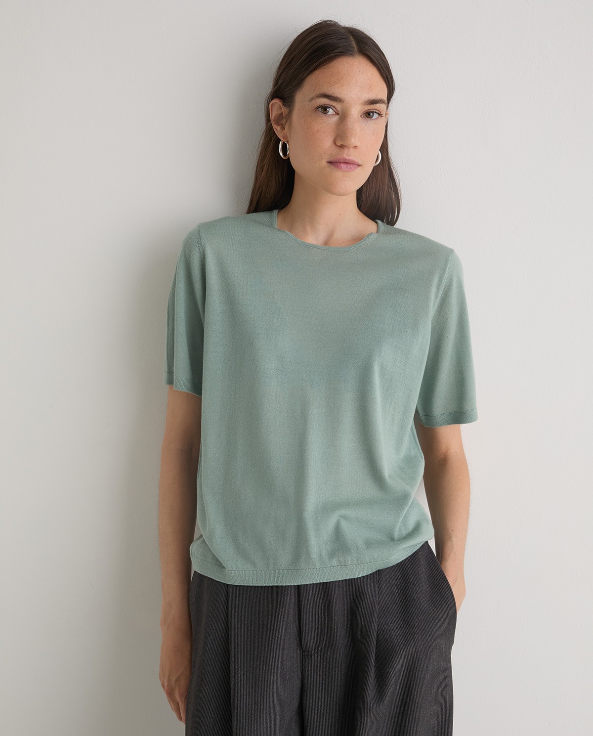 Jersey verde de manga corta confeccionado en 100% lana merino. Corte recto, escote redondo y acabados en canalé. Suavidad y calidez natural. 2