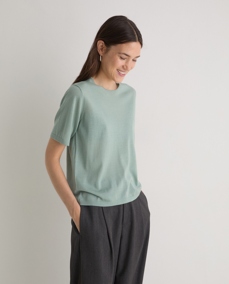 Jersey verde de manga corta confeccionado en 100% lana merino. Corte recto, escote redondo y acabados en canalé. Suavidad y calidez natural.