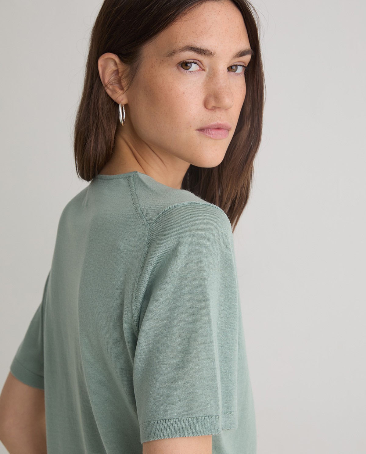 Jersey verde de manga corta confeccionado en 100% lana merino. Corte recto, escote redondo y acabados en canalé. Suavidad y calidez natural. 1
