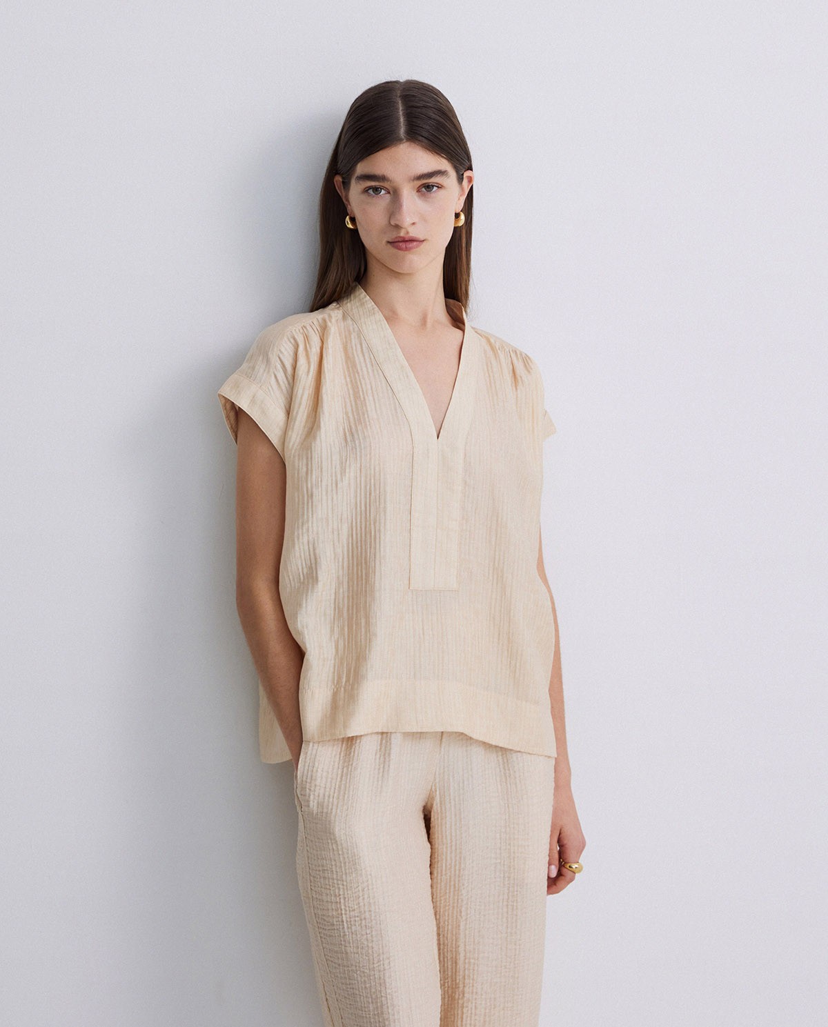 Blusa ondulaciones cuello pico vainilla