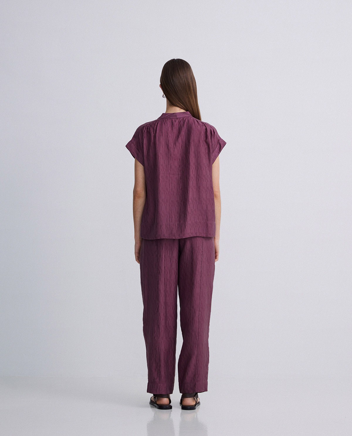 Blusa ondulaciones cuello pico berenjena