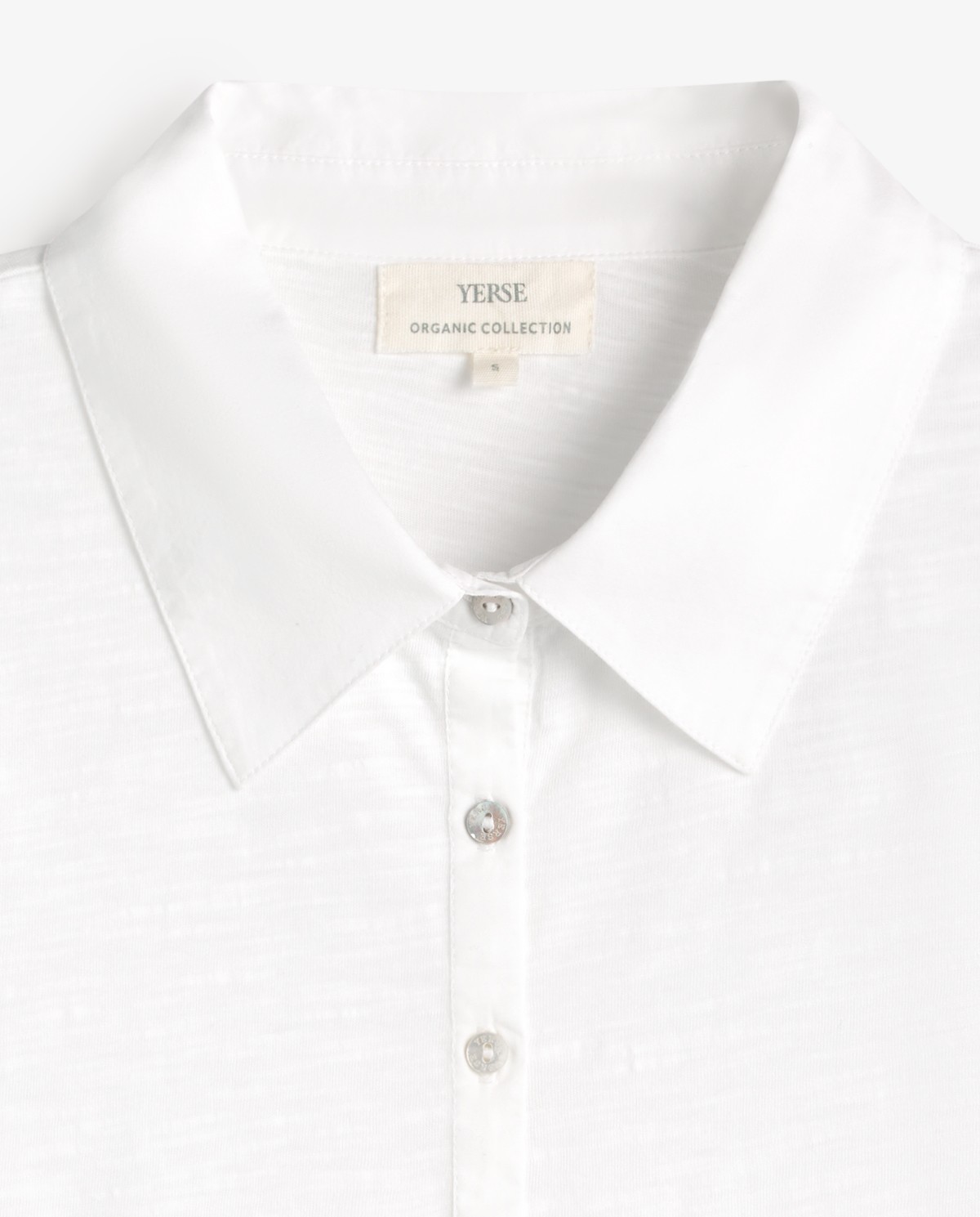 Camiseta cuello polo algodón orgánico en color blanco, vista frontal con detalle del tejido 6