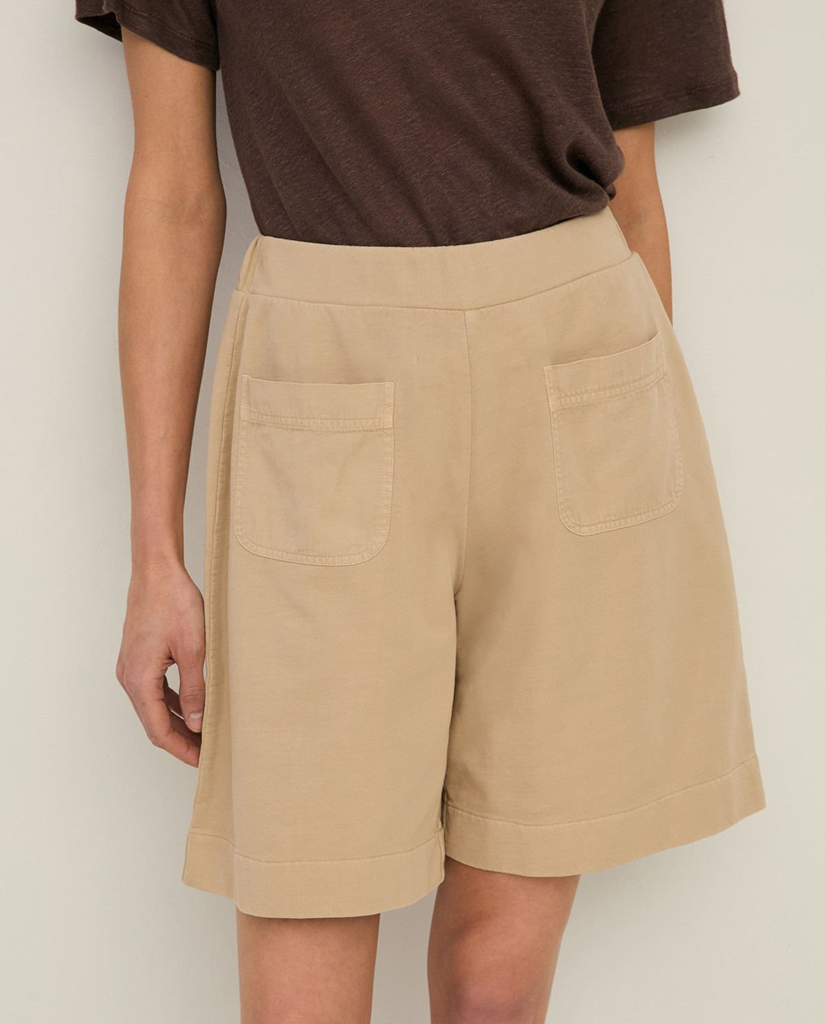 Shorts algodón orgánico detalle bolsillos en color arena, vista frontal con detalle del tejido 1