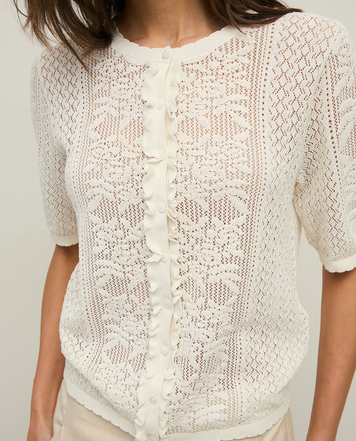 Jersey calado manga corta abullonada en color blanco, vista frontal con detalle del tejido