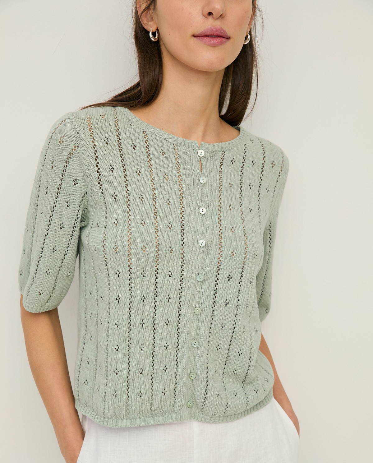 Cárdigan de punto fino calado en color verde, vista frontal con detalle del tejido 1