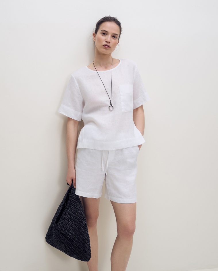 Blusa blanca de lino con manga corta, cuello redondo y bolsillo frontal