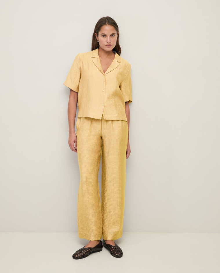 Pantalón fluido wide leg efecto arrugado en color amarillo, vista frontal con detalle del tejido