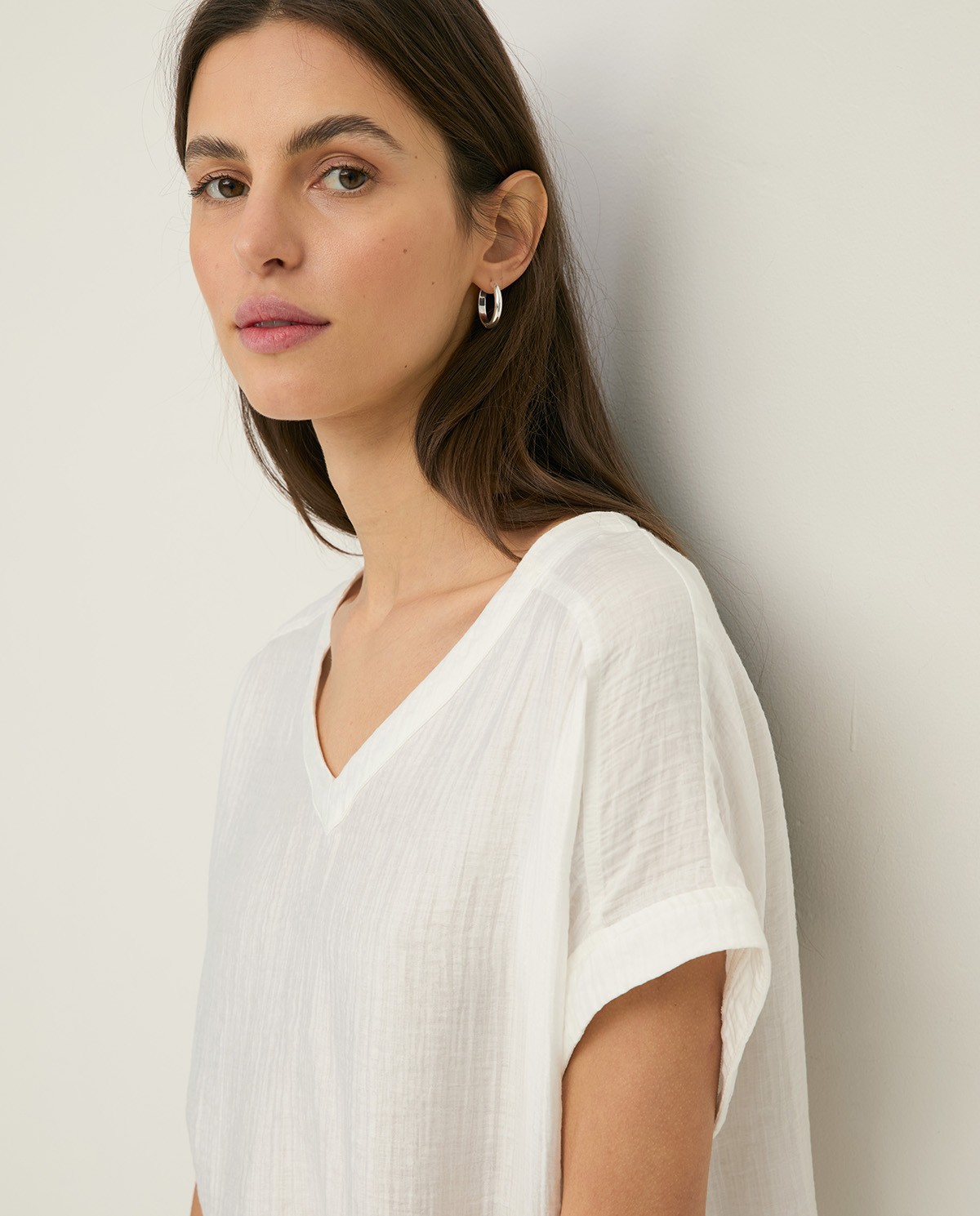 Blusa cuello pico efecto arrugado en color crudo, vista frontal con detalle del tejido 2