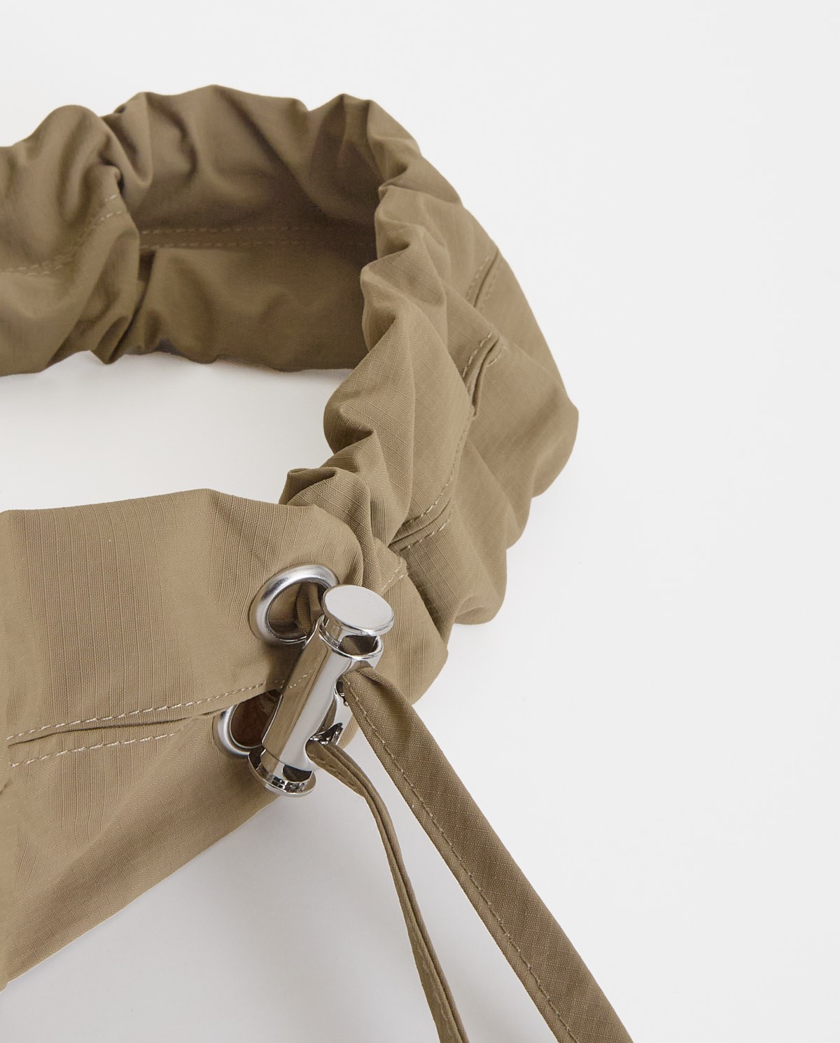 Bolso estilo riñonera con cremallera en color caqui, vista frontal con detalle del tejido 4