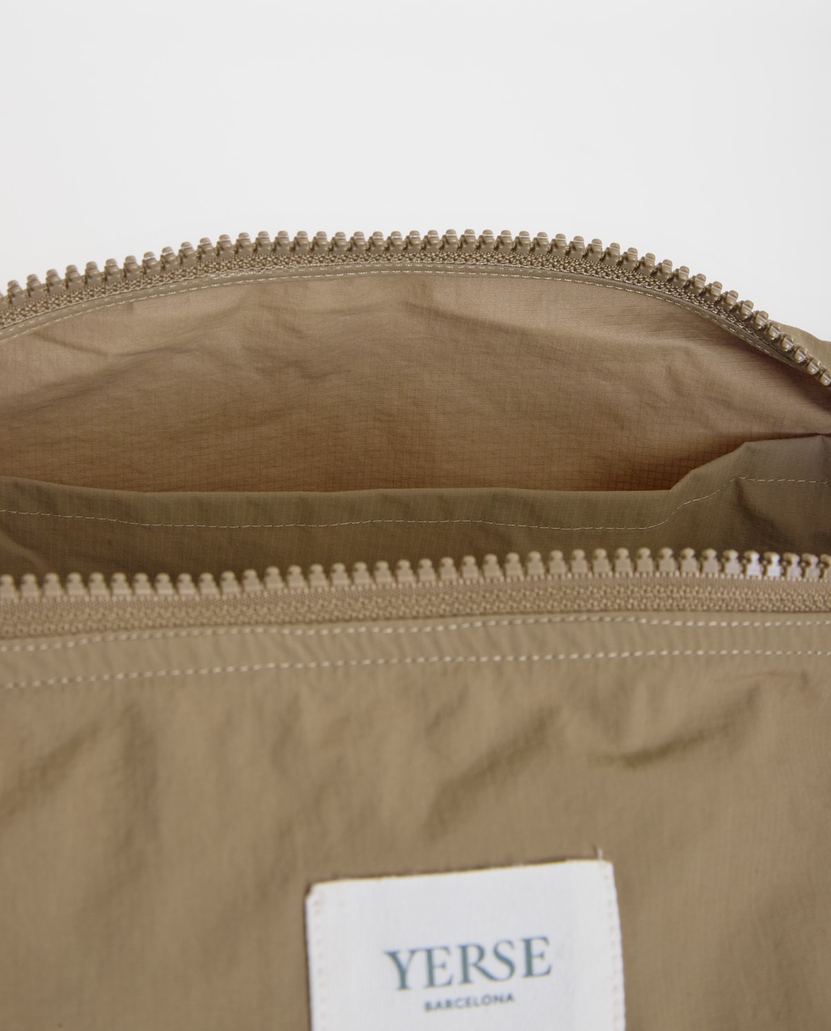 Bolso estilo riñonera con cremallera en color caqui, vista frontal con detalle del tejido 5