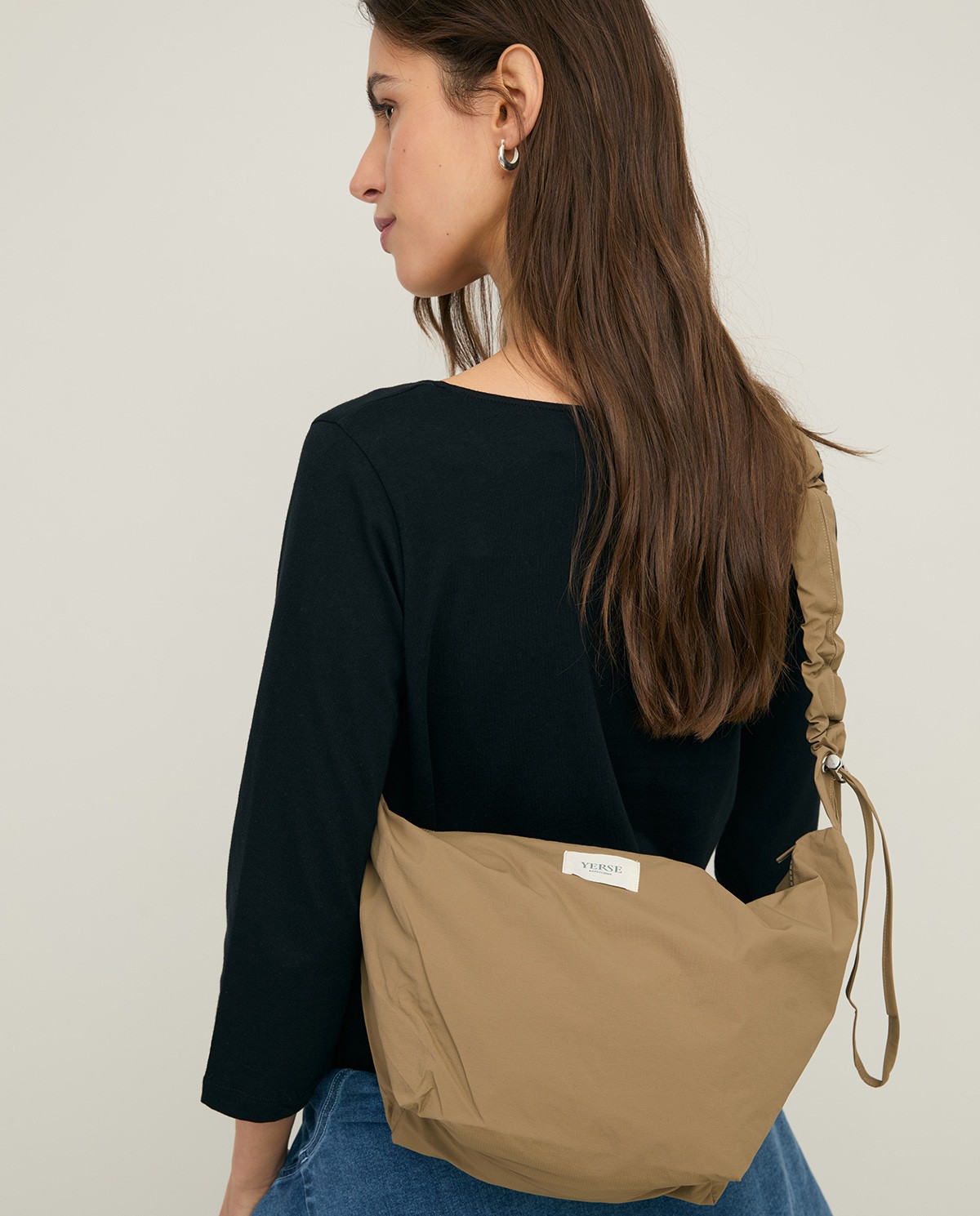 Bolso estilo riñonera con cremallera en color caqui, vista frontal con detalle del tejido