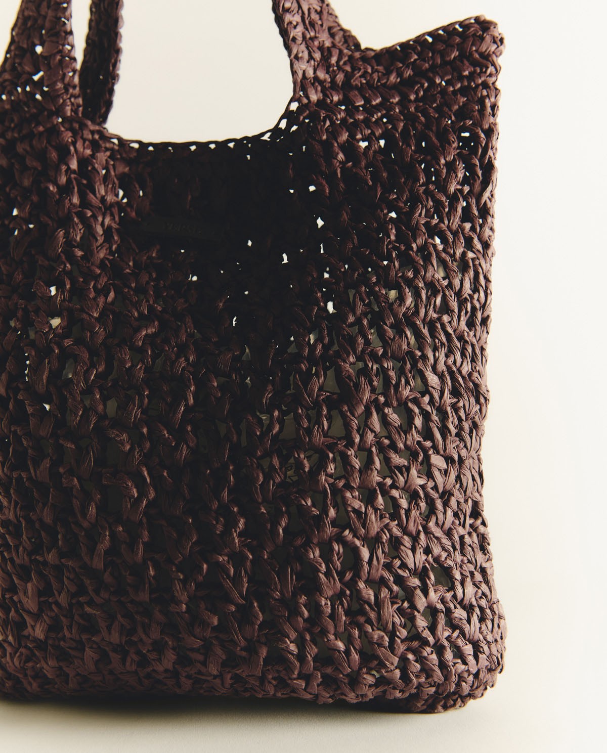 Bolso tote handmade de rafia en color chocolate, vista frontal con detalle del tejido 3