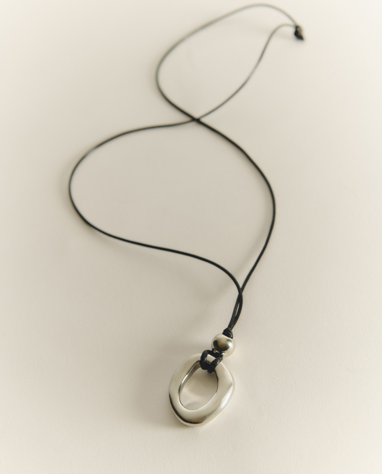 Collier long avec pendentif métallique argenté et cordon noir