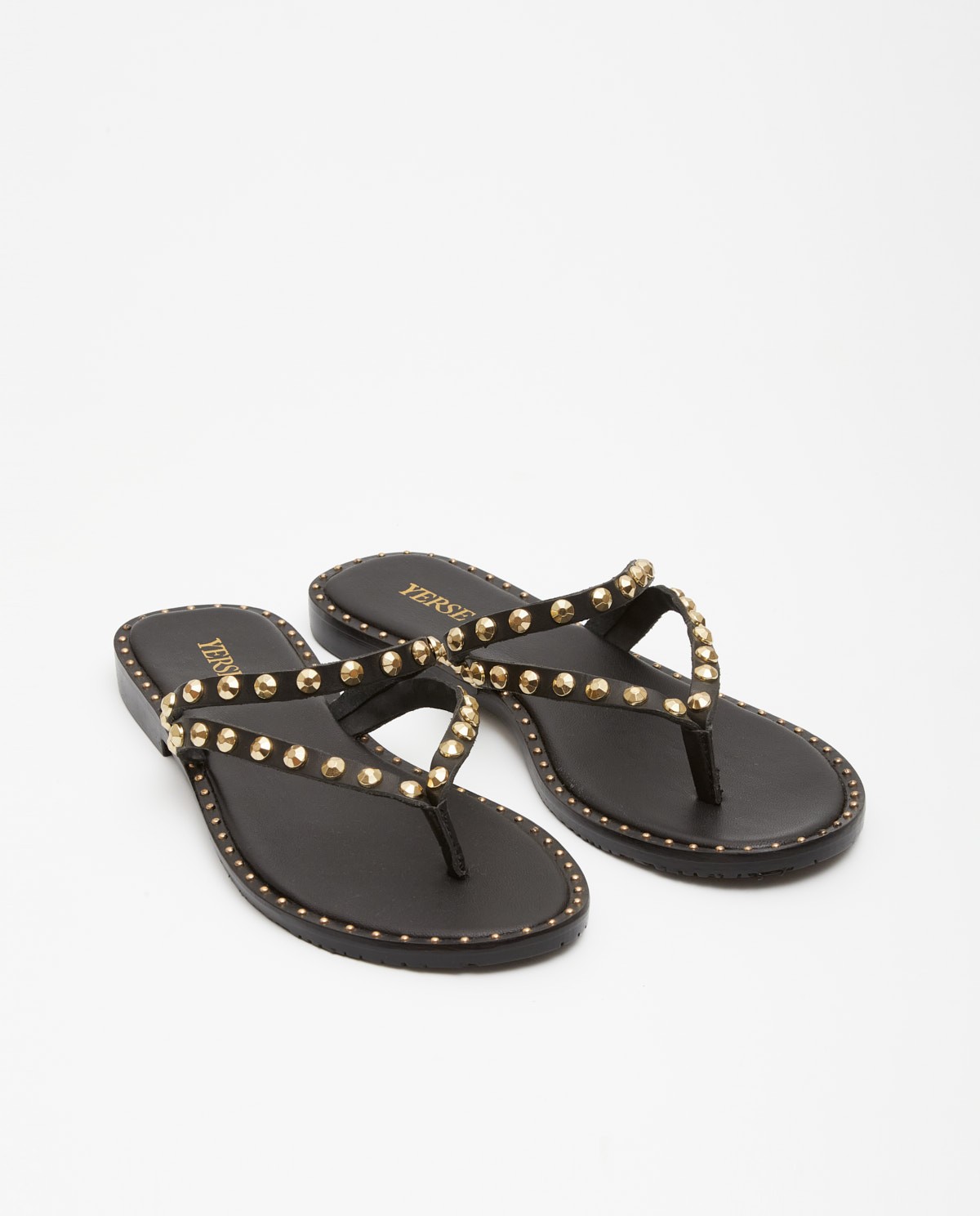 Sandalia plana de piel negra con tiras finas y detalle de tachuelas metálicas