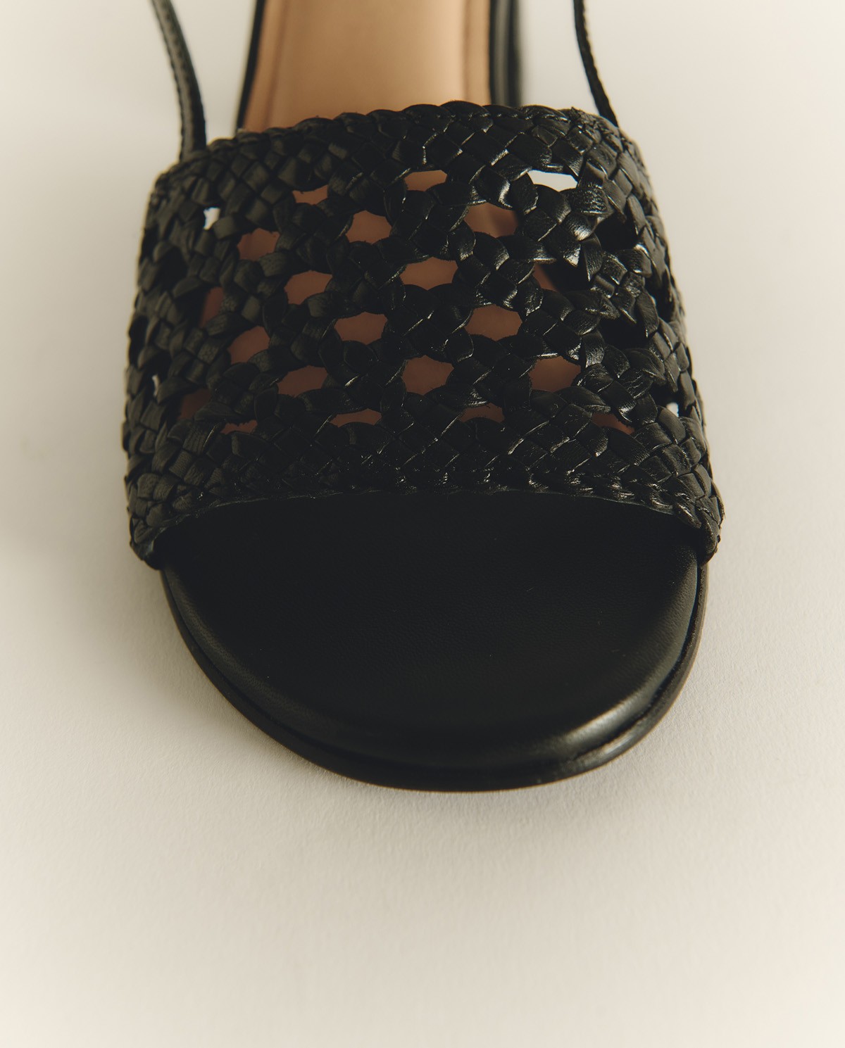 Sandalias de tacón piel trenzada en color negro, vista frontal con detalle del tejido 1