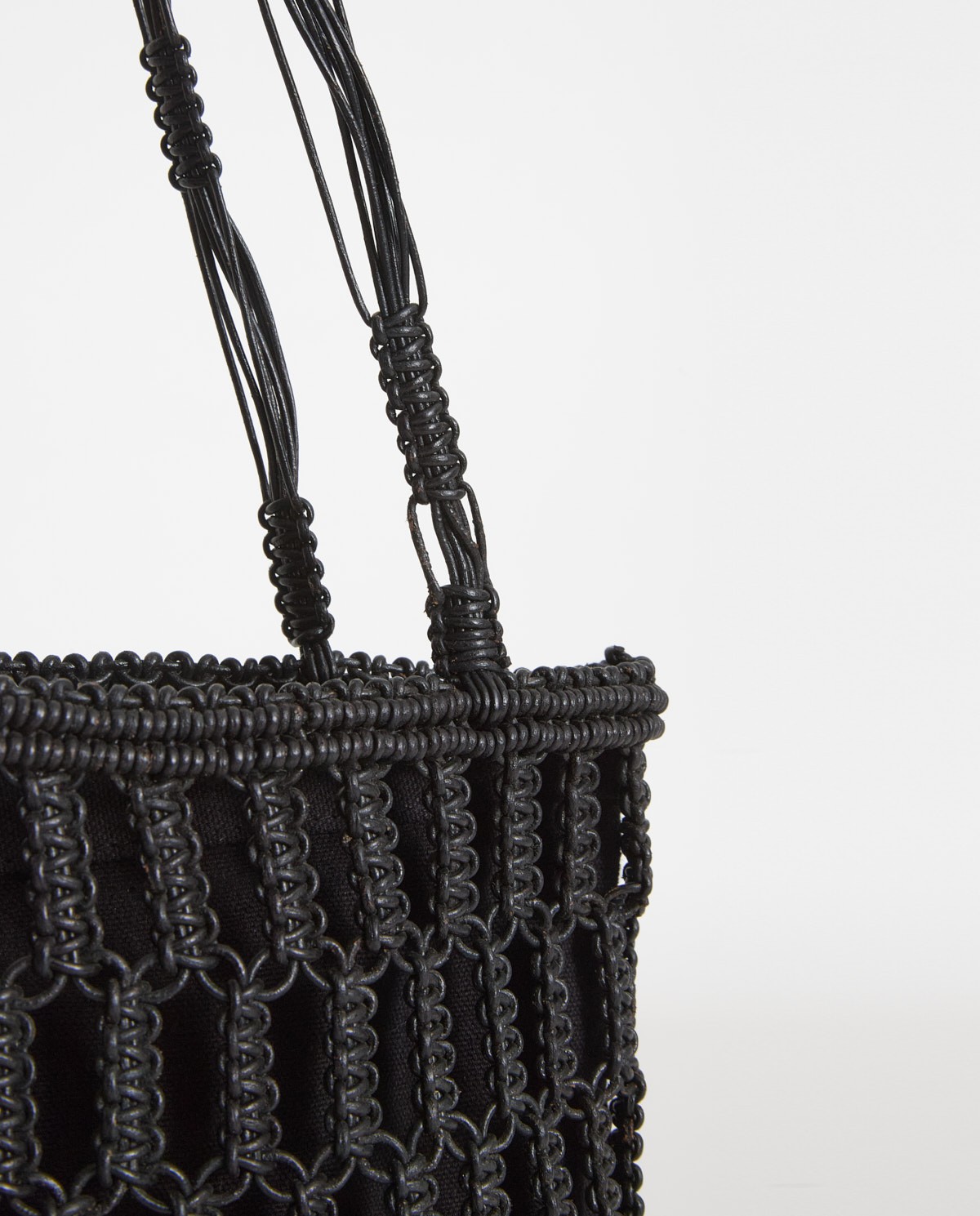 Bolso macramé tubular de piel en color negro, vista frontal con detalle del tejido 4