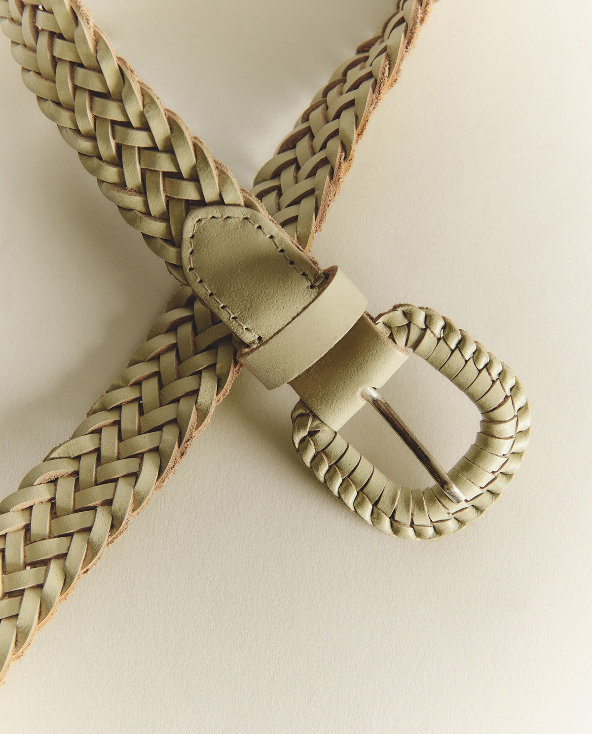 Cinturón de piel trenzado artesanal en color crudo, vista frontal con detalle del tejido