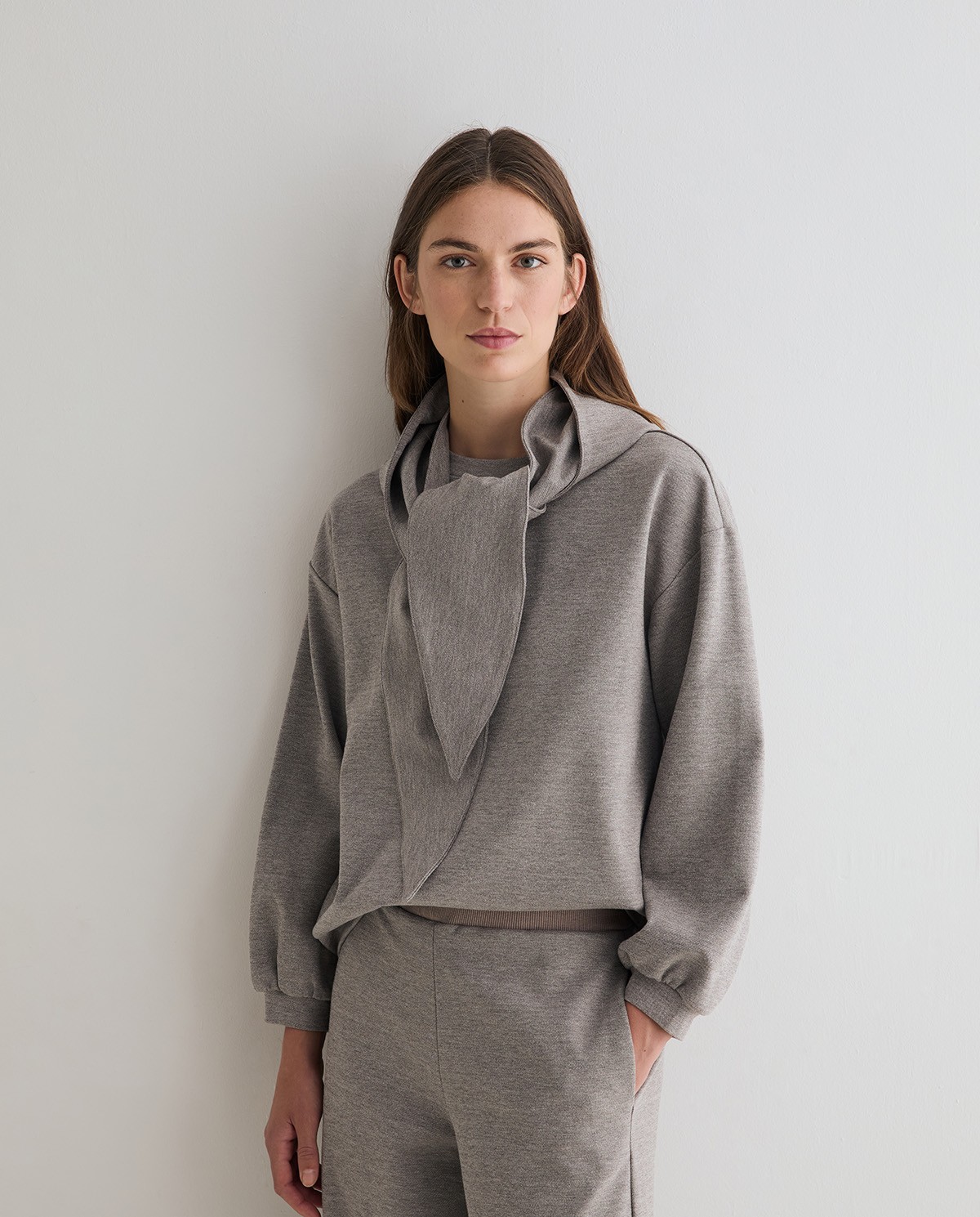 Sudadera oversize con capucha extraíble en color gris, vista frontal con detalle del tejido interlock