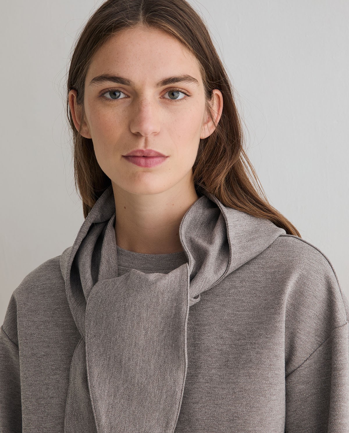 Sudadera oversize con capucha extraíble en color gris, vista frontal con detalle del tejido interlock 1