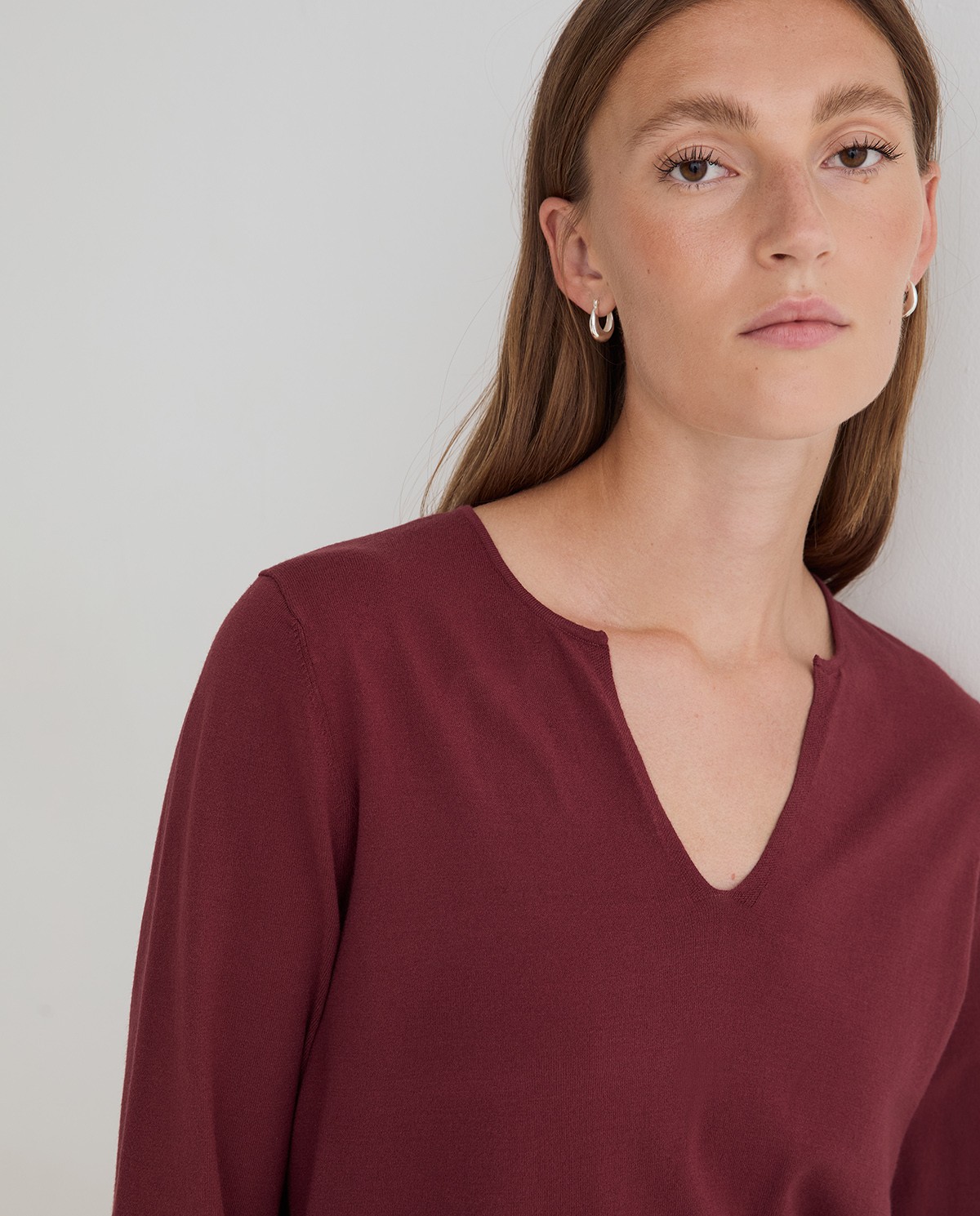 Jersey fino de color granate, vista frontal con detalle del escote de pico y tejido 1
