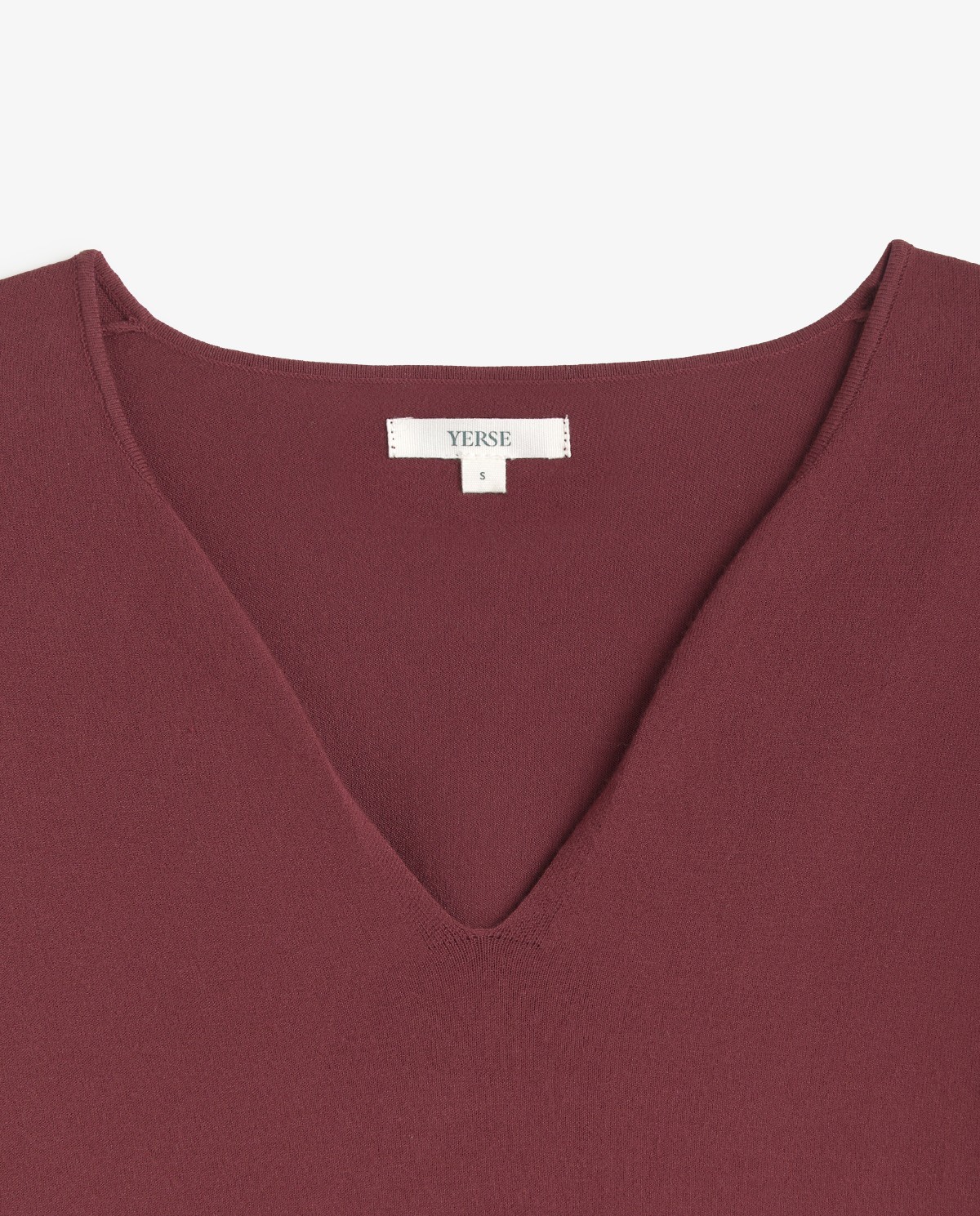 Jersey fino de color granate, vista frontal con detalle del escote de pico y tejido 5