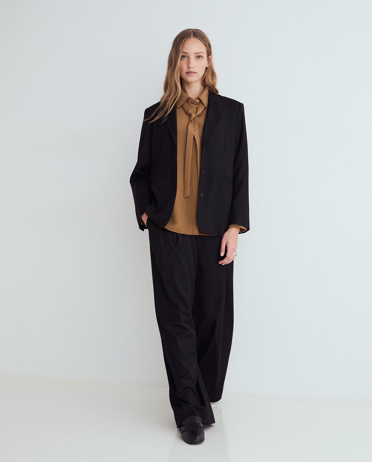 Pantalones de traje wide leg negros, vista frontal con detalle del tejido estructurado 2