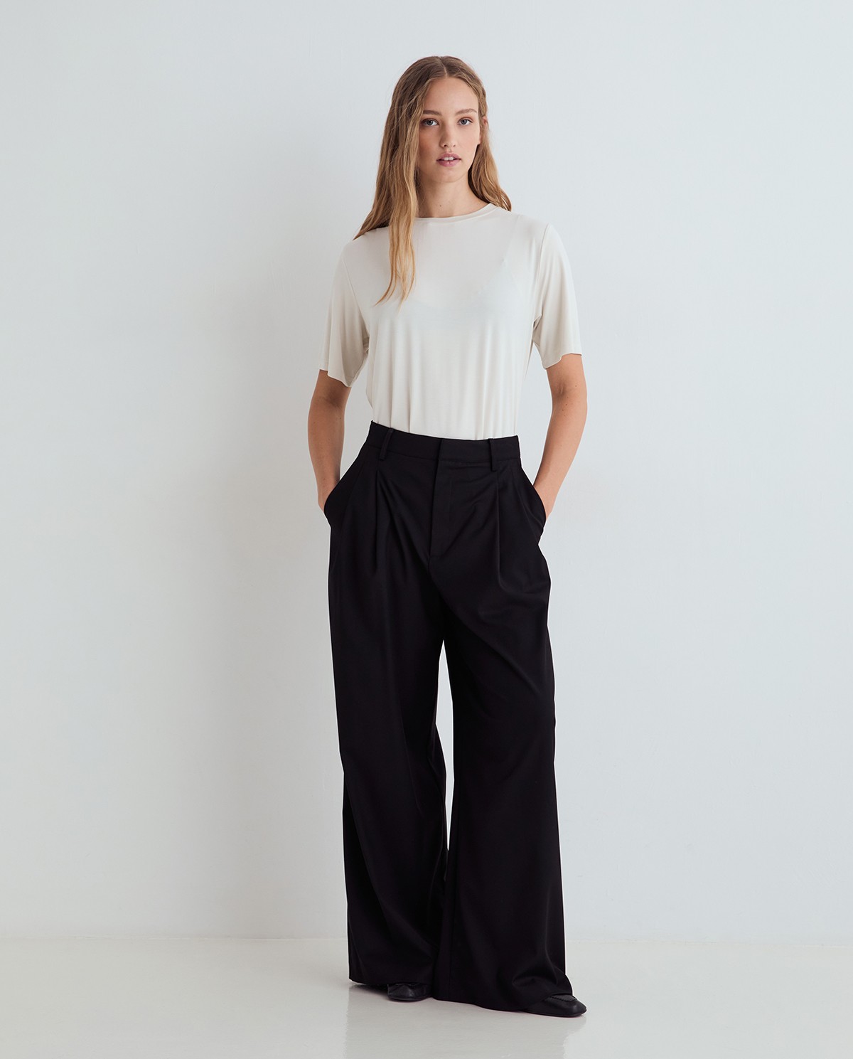 Pantalones de traje wide leg negros, vista frontal con detalle del tejido estructurado 3