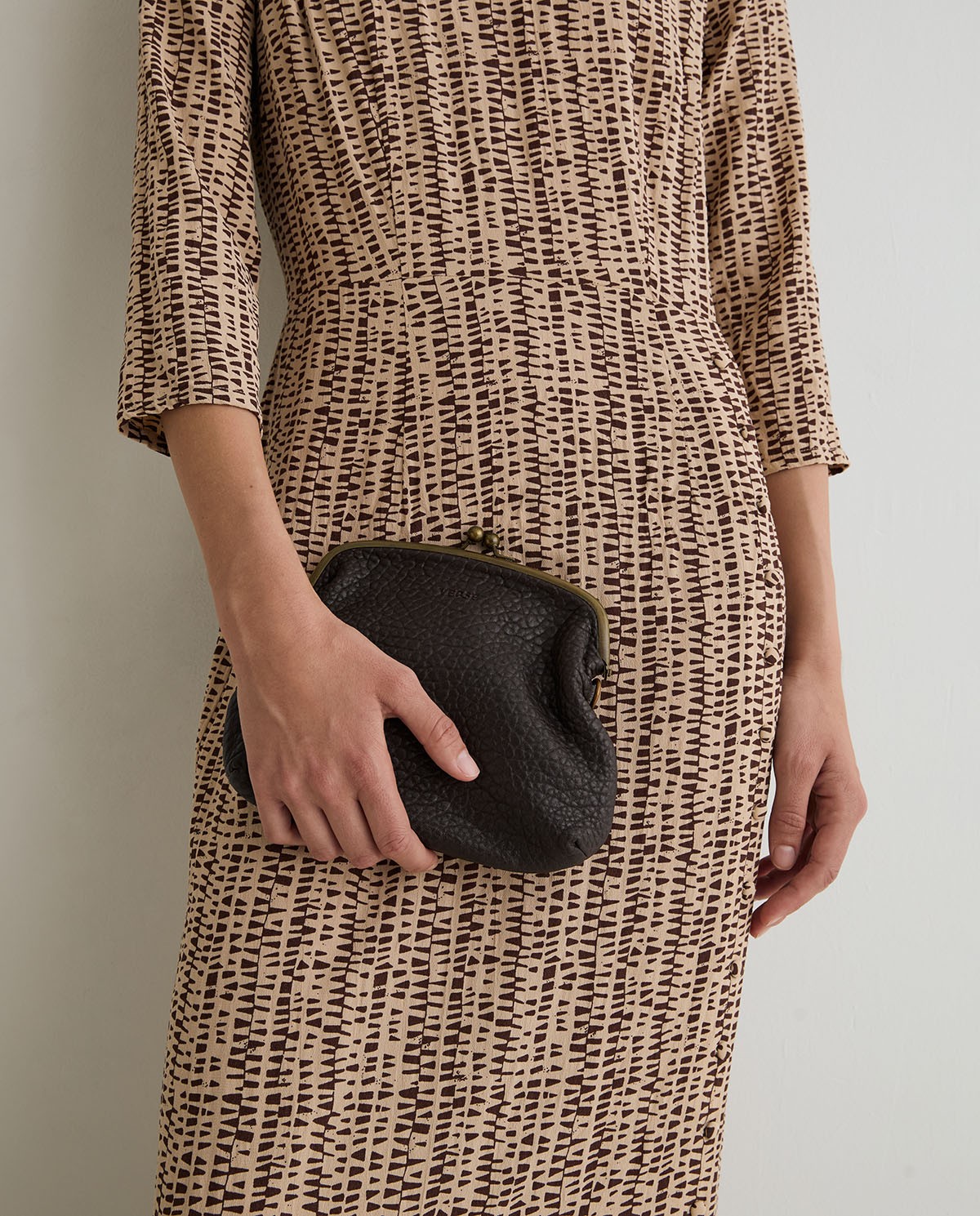 Bolso de piel estilo vintage en color chocolate con cierre de boquilla metálica y asa larga.