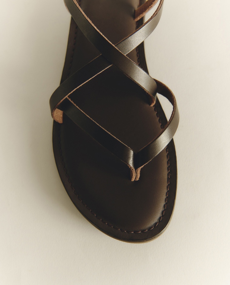 Sandalias planas de piel con tiras cruzadas en color chocolate, vista frontal con detalle del tejido