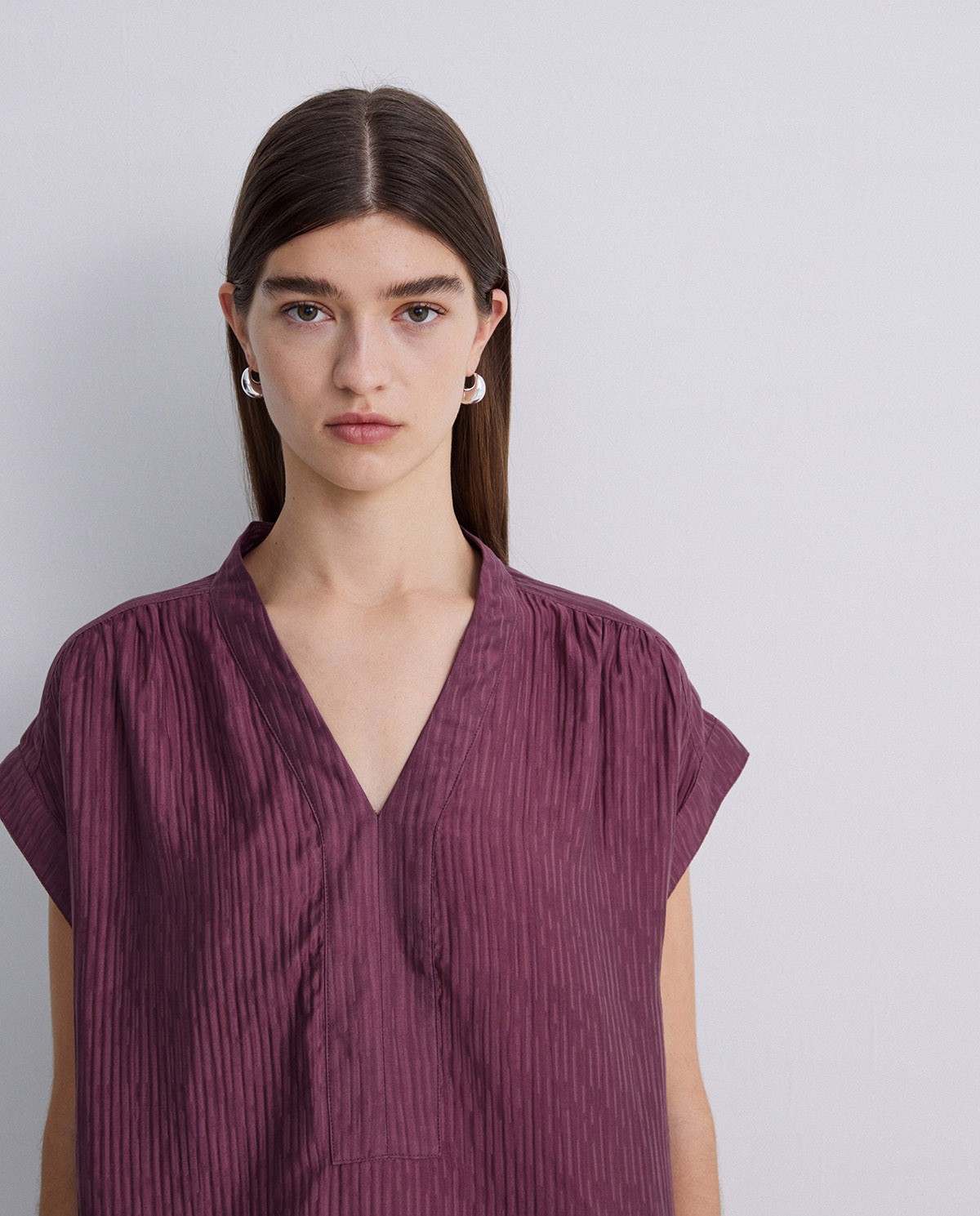 Blusa ondulaciones cuello pico berenjena