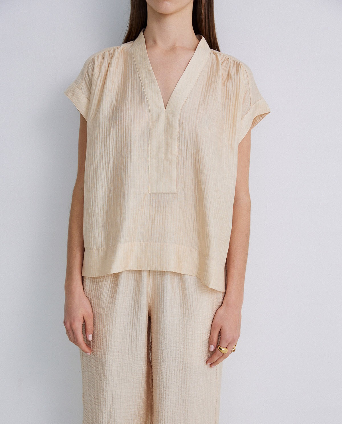 Blusa ondulaciones cuello pico vainilla