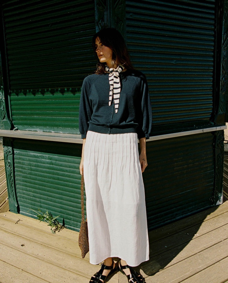 Falda larga detalle pliegues en color blanco, vista frontal con detalle del tejido